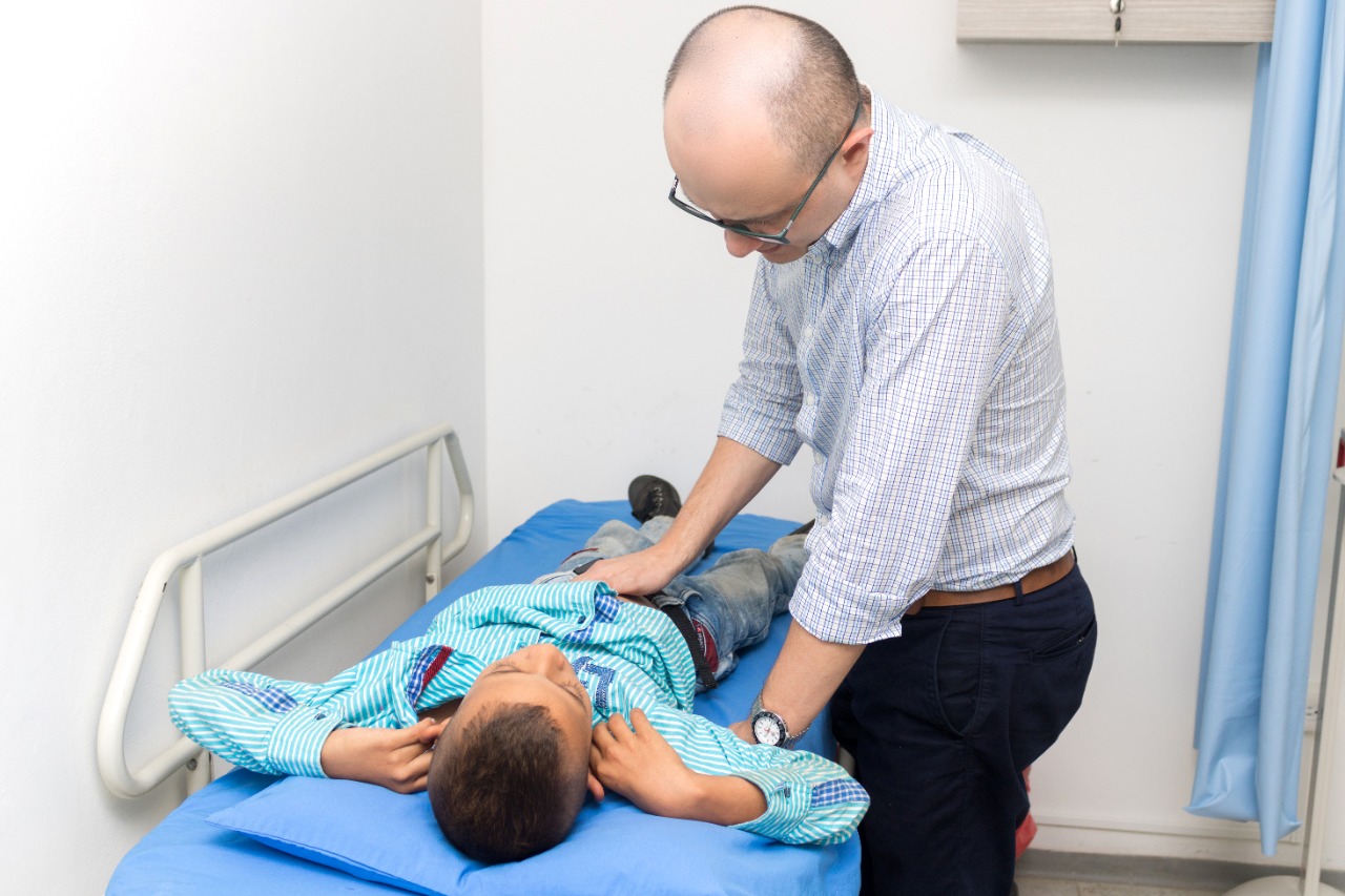 Médico pediátrico revisando a un niño